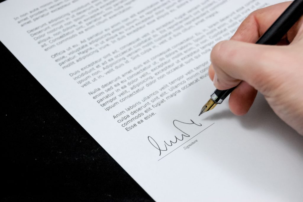 a picture of a hand signing an official document